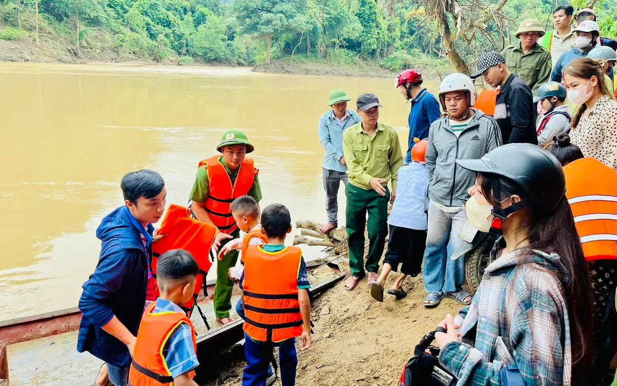 Ngày tựu trường sau trận lũ lịch sử, chính quyền địa phương đã quyết định tổ chức dùng thuyền hỗ trợ học sinh qua sông. Ảnh Lượng Minh.
